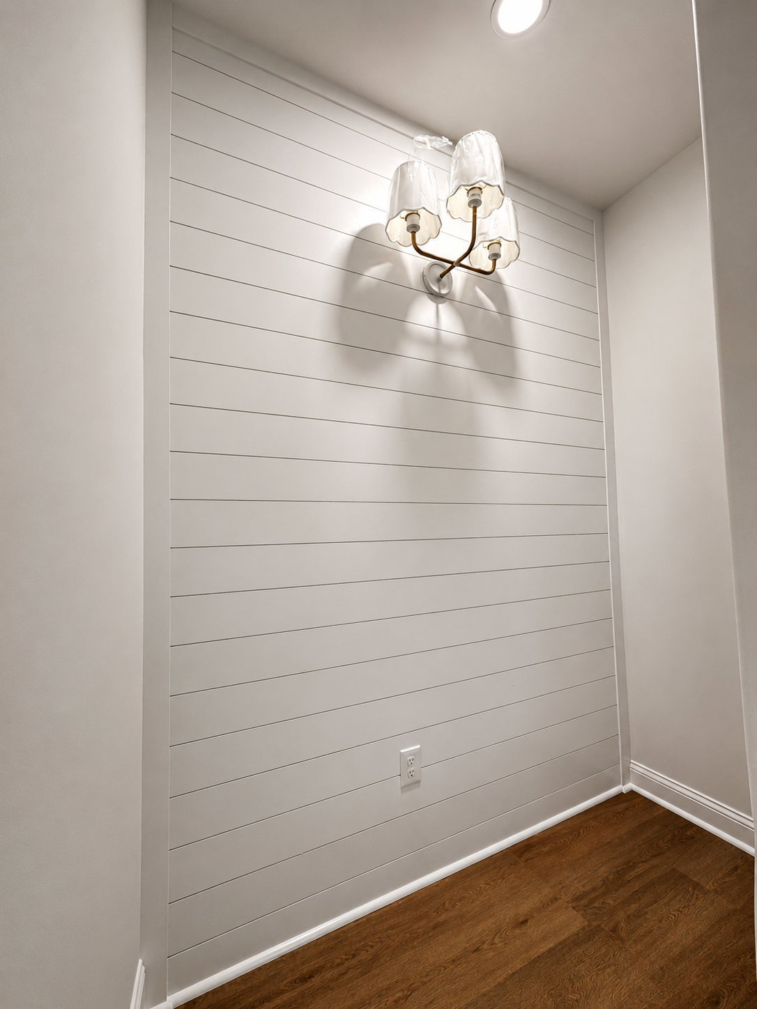 Finished white shiplap accent wall with decorative lighting