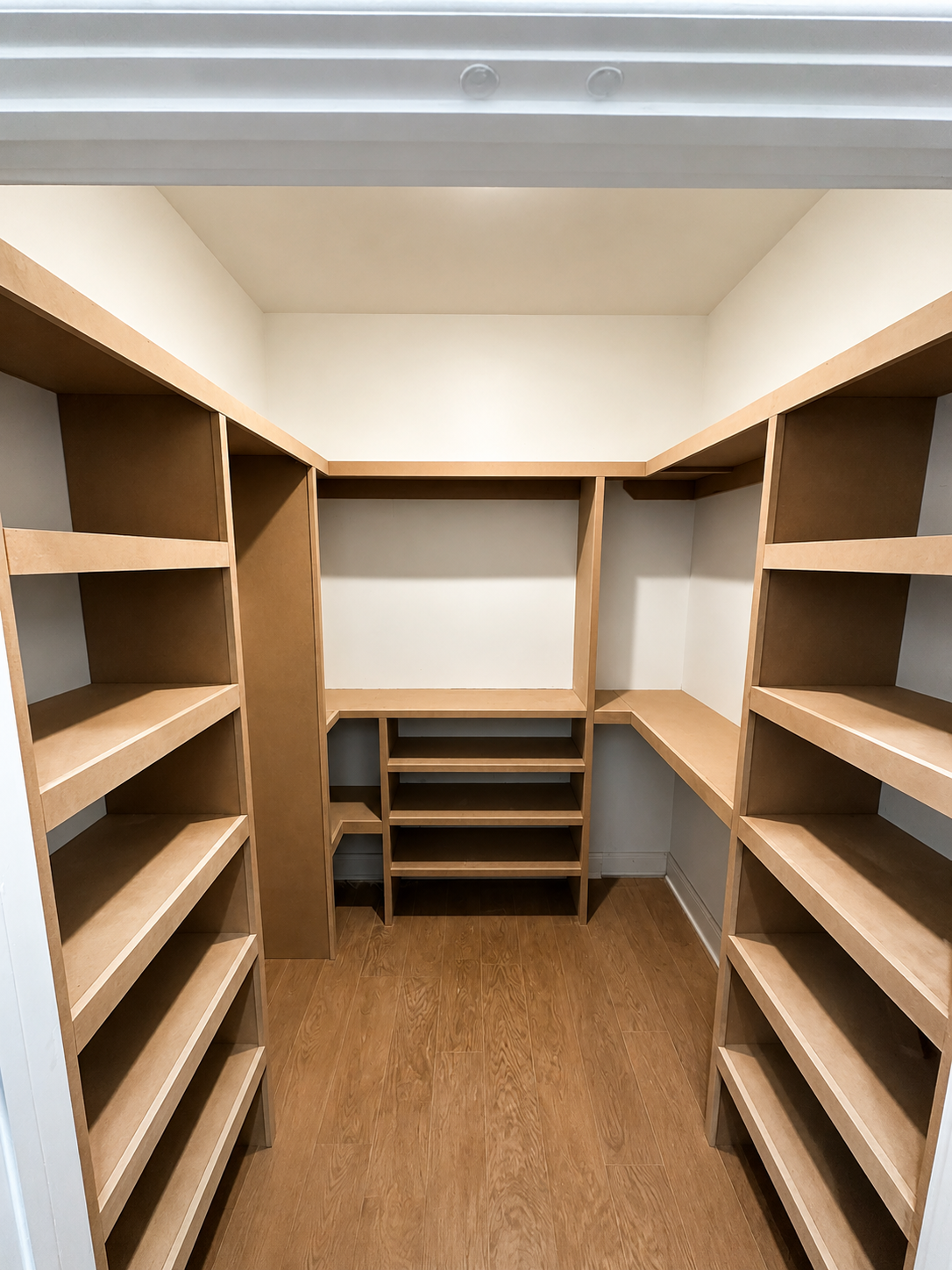 Finished walk-in closet with custom shelving and built-in storage