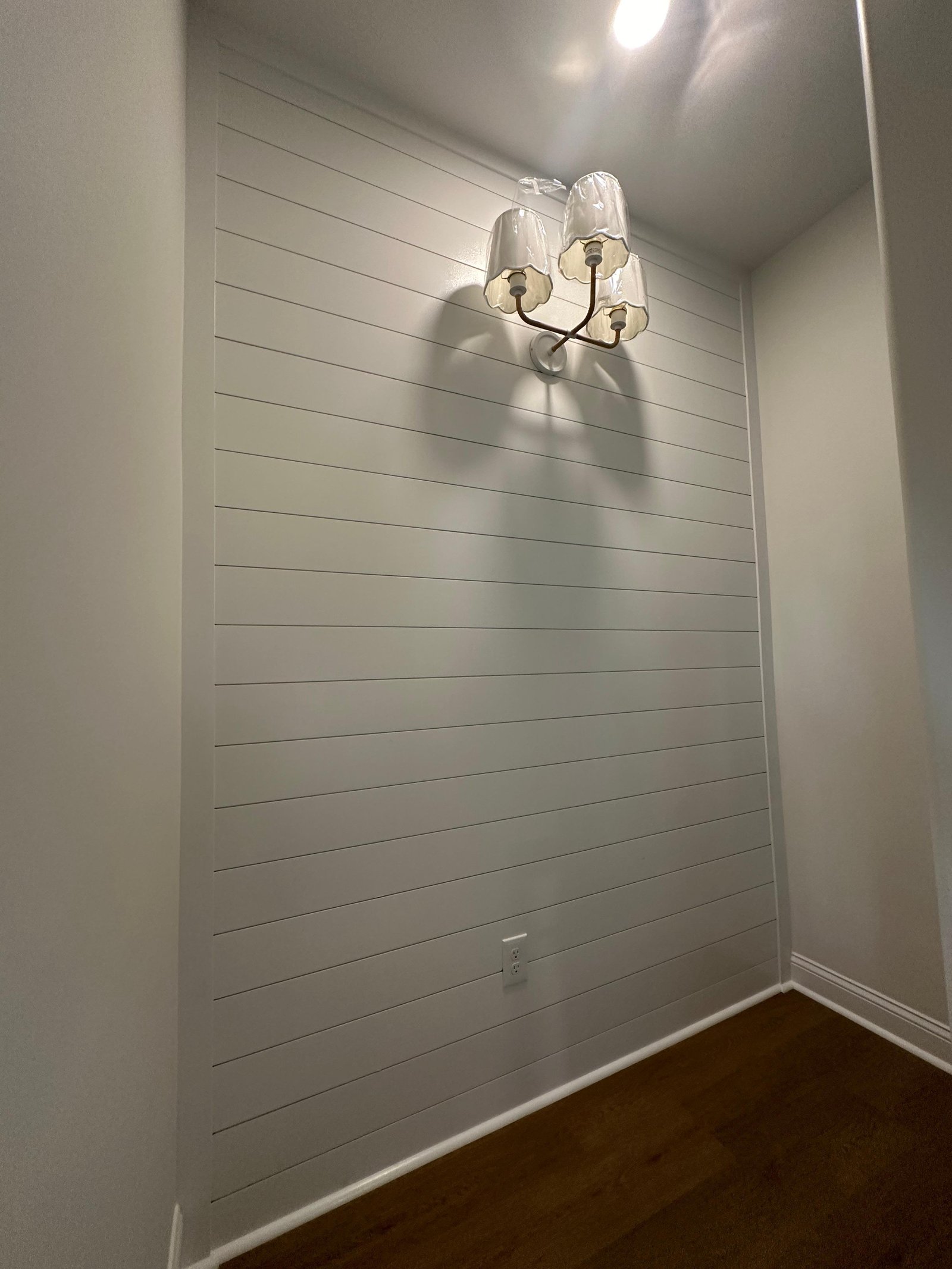 Finished white shiplap accent wall with decorative lighting