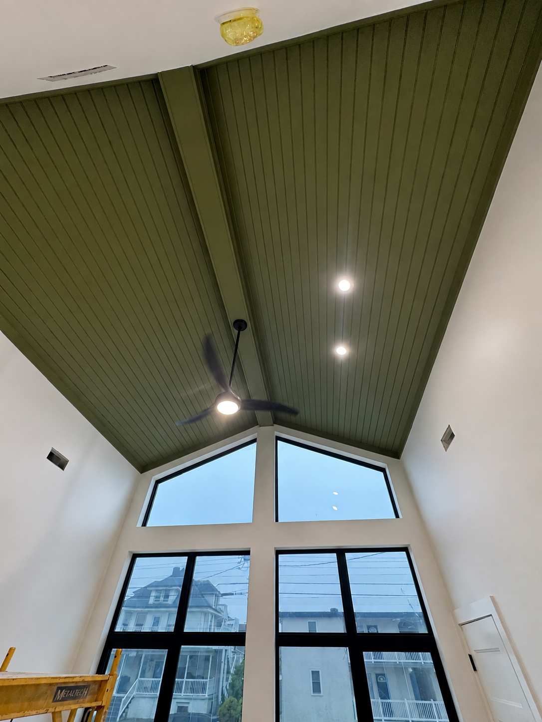 Completed green vaulted ceiling with beams and lighting