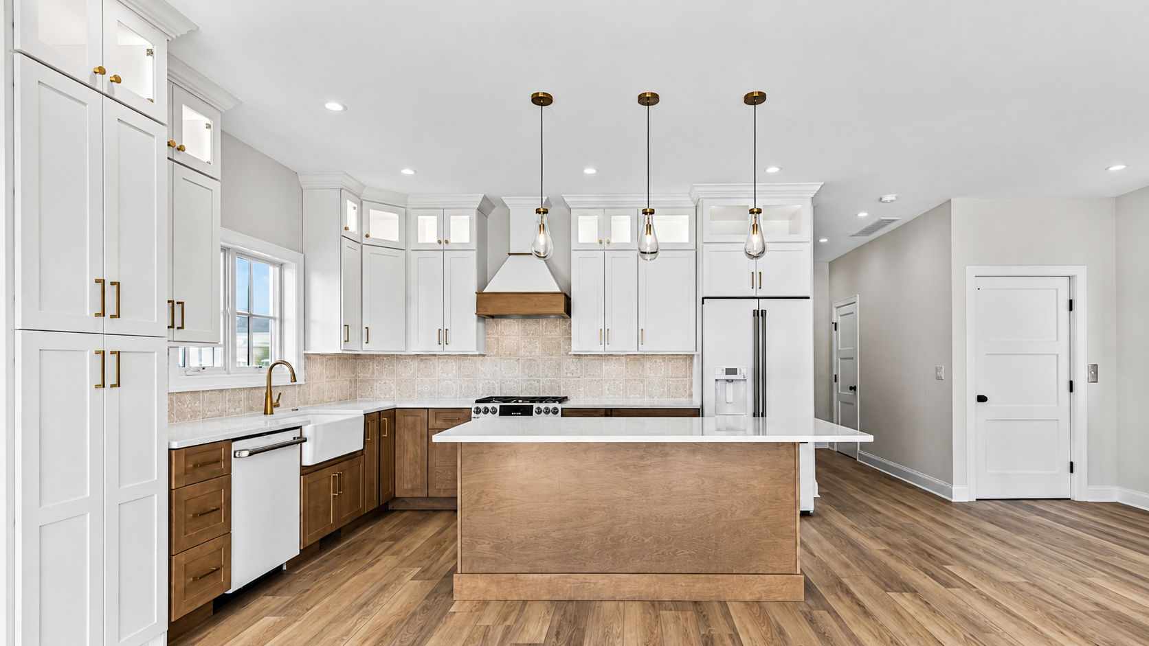 Finished custom kitchen cabinetry with a large island and white cabinets